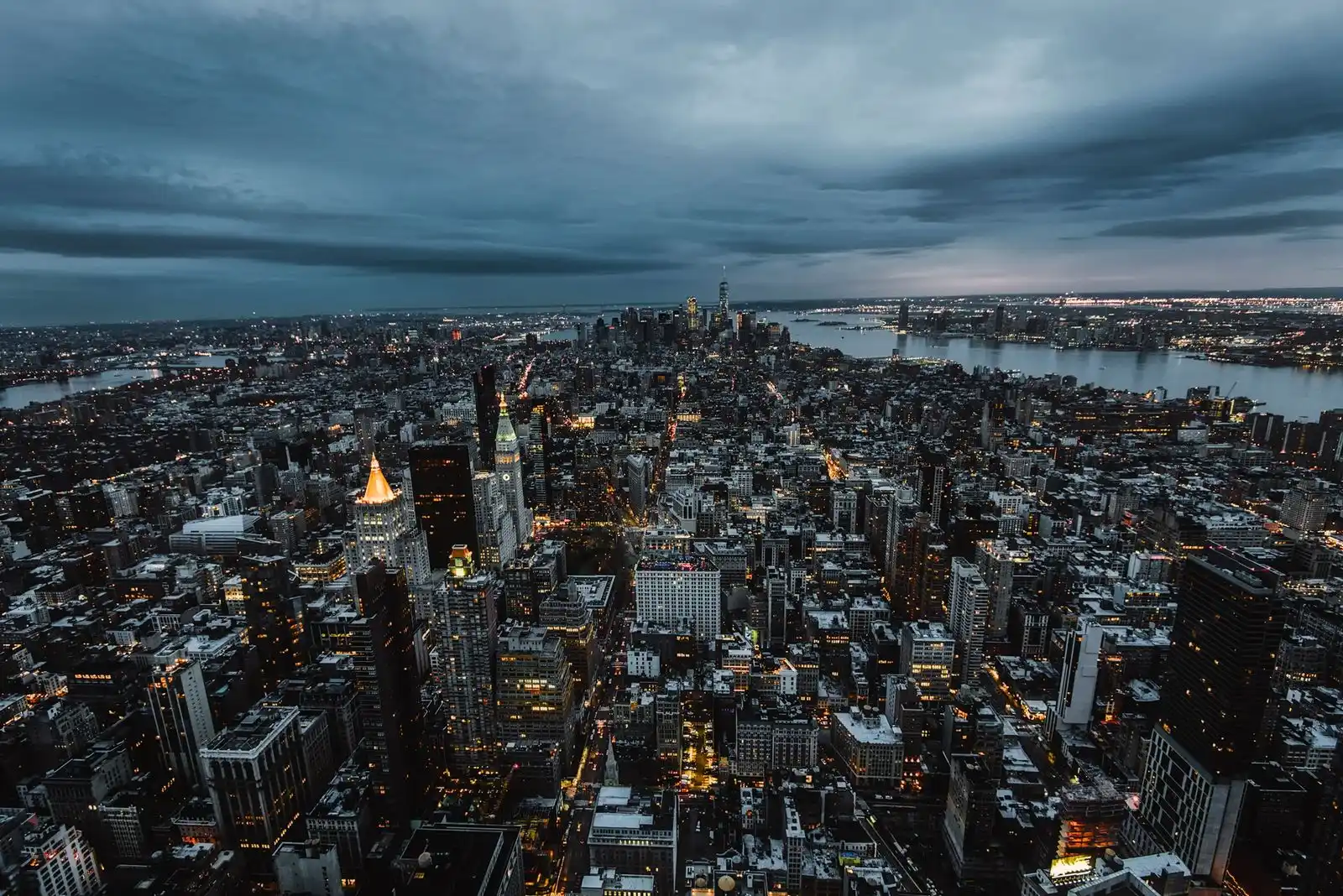 Vista aérea de una ciudad al anochecer con edificios iluminados