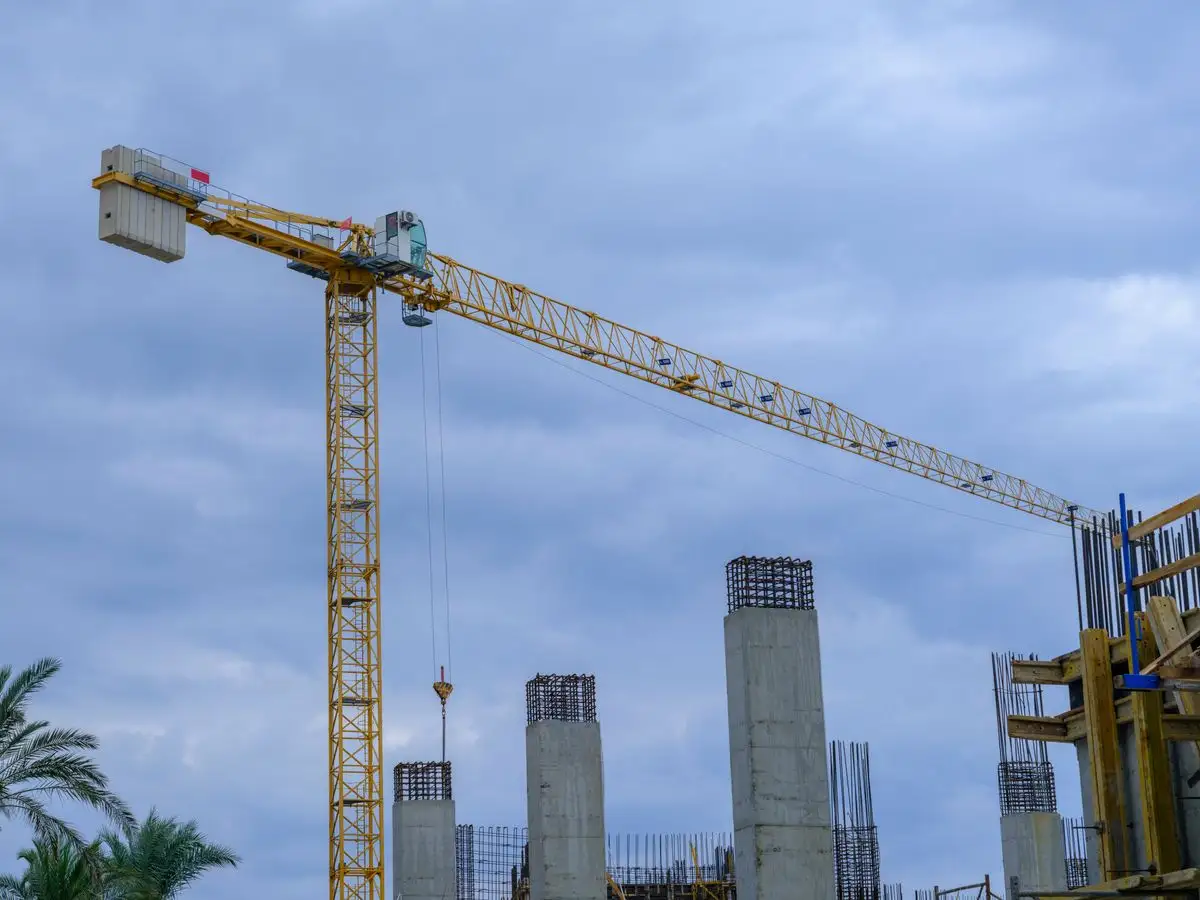 Grúa torre sobre columnas de hormigón armado en una obra en curso